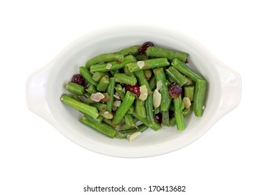 A Dish Of Healthy Green Beans With Cranberries And Slivered Almonds On A White Background.