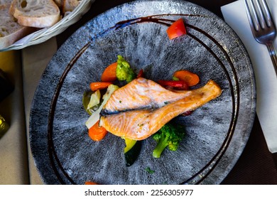 Dish of Mediterranean cuisine - baked salmon in white sauce served with blanched vegetables - Shutterstock ID 2256305977