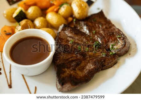 Dish in old bistro in Limoges, France, Limousin cattle beef steak served with oven baked potatos, served with light broth or gravy