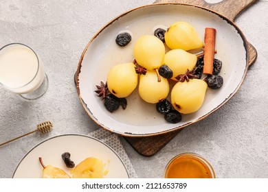 Dish with poached pears, prunes, anise and cinnamon on light table