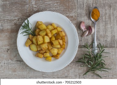 A dish of potatoes with garlic, rosemary, olive oil and tumeric.