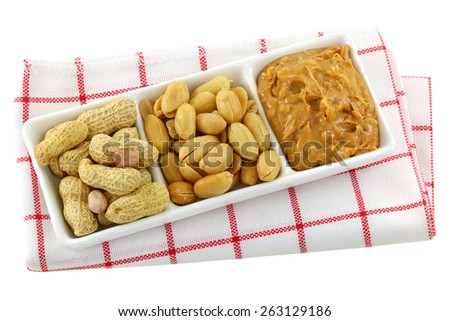 A dish of roasted groundnuts, salted peanuts and peanut butter, isolated on white