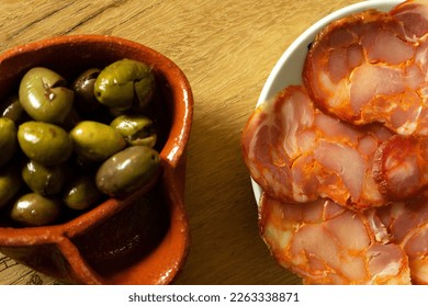 Dish with slices of paio and olives in a traditional Alentejo olive tree made of clay. Paio is a traditional pork sausage from the Alentejo region of Portugal. - Shutterstock ID 2263338871