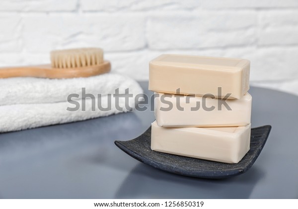 Dish with\
soap bars on grey table. Space for\
text