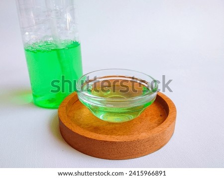 Dish soap in a pump bottle and small bowl, isolated white background