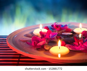 dish spa with floating candles, orchid, in garden