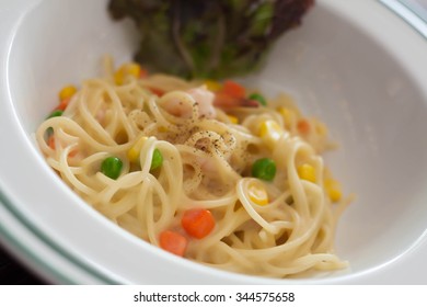 Dish Of Spaghetti Carbonara With Carrots, Corn, Peas, Shrimp.