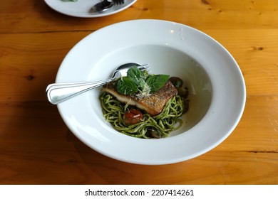 A Dish Of Spaghetti Pesto With Grilled Sea Bass Fillet On The Wooden Table.