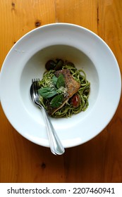 A Dish Of Spaghetti Pesto With Grilled Sea Bass Fillet On The Wooden Table.