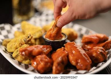 Dish Of Spicy Chicken Wings With Hand