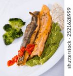 Dish of tasty steak of fried river trout fillet with broccoli and sause tartar on plate