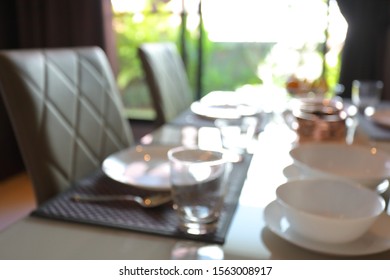 dish ware sets arrange on dining table inside eating room of home, image blur background