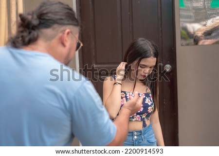 A disheartened female teenager looks down as she heard the hurtful words her step father said to her. Possible domestic abuse.