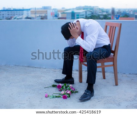 A disheartened man in a suit, broken-hearted after being rejected.
