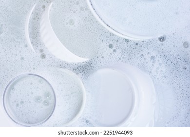 Dishes and bowls in water and bubbles of dishwashing liquid