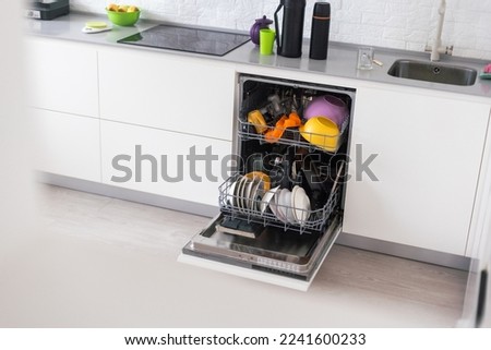 Dishes and cutlery on dishwashing machine. Clean dishes