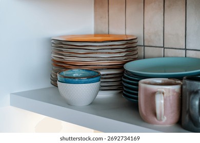Dishes on the shelf, a stack of clean plates and bowls.