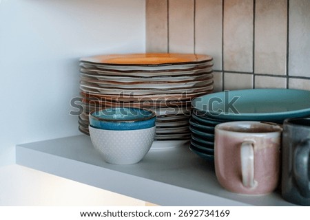 Dishes on the shelf, a stack of clean plates and bowls.