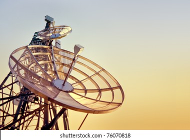dishes on a telecommunications tower at the sunset