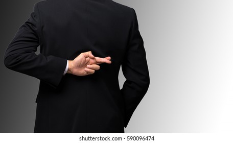 Dishonest businessman telling lies, lying male entrepreneur holding fingers crossed behind his back