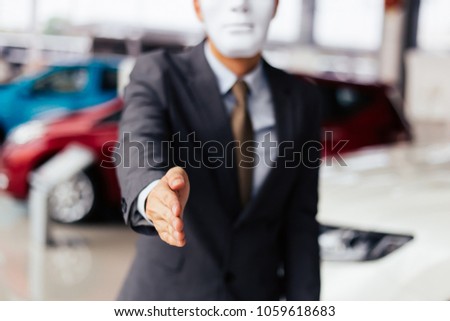 Dishonest and evil salesman in business suit in car dealership company handshaking welcome customers to exploit and deceive customers - fraud and bad quality service in business concept