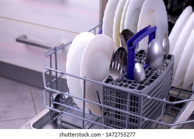 Dishwasher Basket With Dirty White Dishes And Cutlery In The Kitchen. Close-up View.