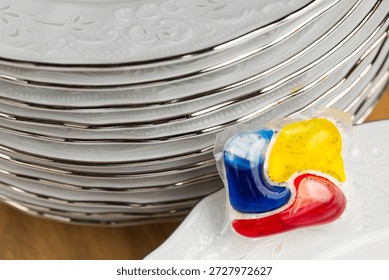 Dishwasher Detergent Pod With Stack Of Plates