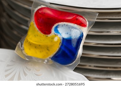 Dishwasher Detergent Pod With Stack Of Plates