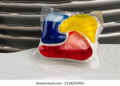 Dishwasher Detergent Pod With Stack Of Plates