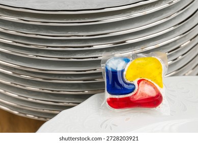 Dishwasher Detergent Pod With Stack Of Plates