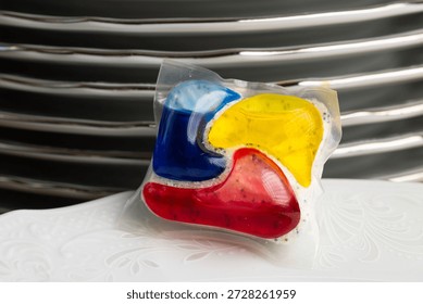 Dishwasher Detergent Pod With Stack Of Plates