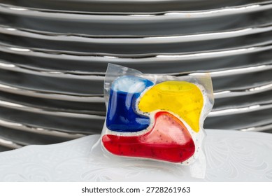 Dishwasher Detergent Pod With Stack Of Plates
