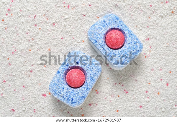 Dishwasher detergent tablets red and blue\
color on powder. Choice concept. Copy\
space