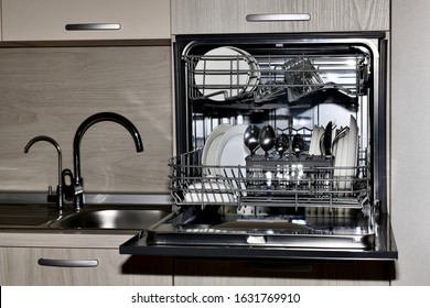  Dishwasher with dishes, built at the sink level with dryer and two taps with tap water and filtered, front view.