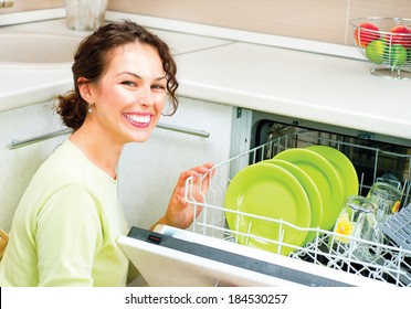 Dishwasher. Happy Young Woman In The Kitchen Doing Housework. Dishwasher Machine, Dishwashing. Wash-up. Smiling Girl Using Dishwasher Machine