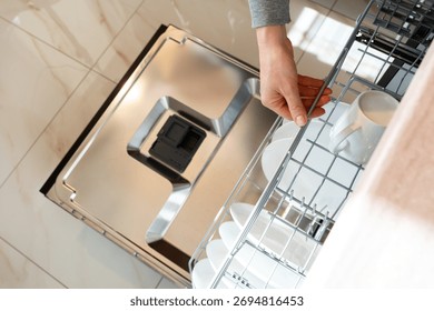 Dishwasher machine. Top view of loading dishwasher rack with plates.