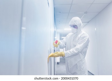 Disinfect Employee In Medical Suit Cleans Hotel Apartment Lobby From Contamination By Virus And Bacteria. Man Holding Antiseptic Spray Against Coronavirus.