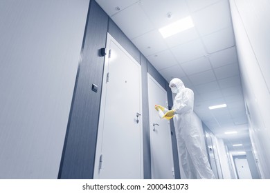 Disinfect Employee In Medical Suit Cleans Hotel Apartment Lobby From Contamination By Virus And Bacteria. Man Holding Antiseptic Spray Against Coronavirus.