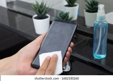 Disinfect, Sanitize, Hygiene Care. Cleaning Fingerprint On Mobile Phone Touch Screen For Disinfection, Prevention Of Germs Spreading During Infections Of COVID-19 Coronavirus