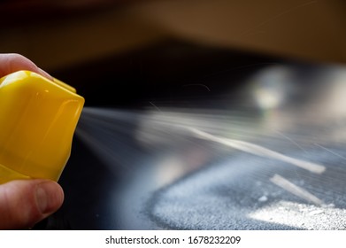 Disinfectant Being Spayed From An Aerosol Can Onto A Metal Black Desk