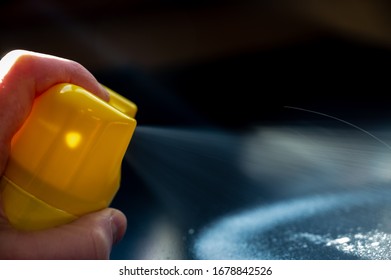 Disinfectant Being Spayed From An Aerosol Can Onto A Metal Black Desk