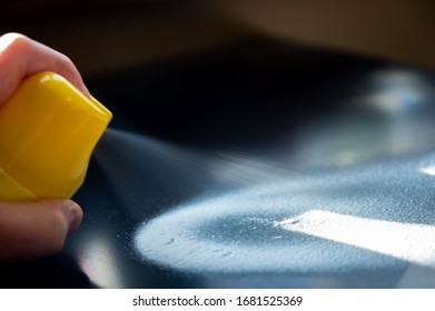 Disinfectant Being Spayed From An Aerosol Can Onto A Metal Black Desk