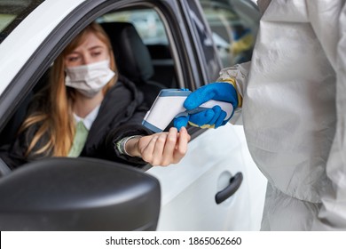 Disinfectants Check Woman In Car For Covid 19 Before Granting Entry Clearance, Outdoors. Focus On Hands Examining The Temperature With The Use Of Equipment