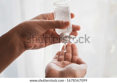 Disinfecting hands. Taking disinfection alcohol gel on hands in white light to prevent virus epidemic. Prevention of flu disease. Cleaning and disinfecting hands in proper way. Foto stock © 