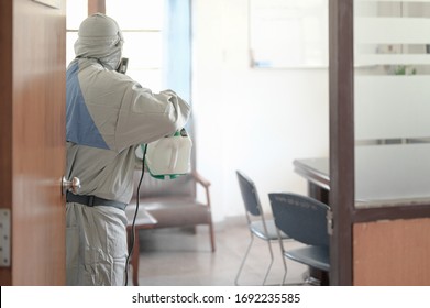 Disinfecting Of Office To Prevent COVID-19, Person In White Hazmat Suit With Disinfect In Office, Coronavirus Concept