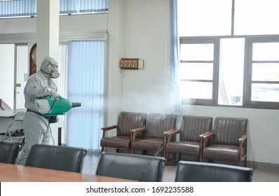Disinfecting of office to prevent COVID-19, person in white hazmat suit with disinfect in office, coronavirus concept - Shutterstock ID 1692235588