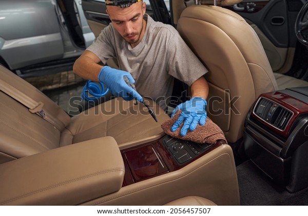 Disinfection of car dashboard with air gun at\
service station