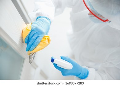 Disinfection and cleaning door handles of house from infection with virus and microbes in biochemical suit. Coronavirus protection concept. - Powered by Shutterstock