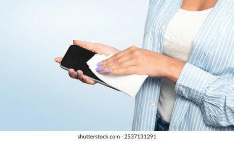 Disinfection Concept. Unrecognizable Woman Disinfecting Smartphone Cleaning It With Sanitizer And Tissue Over White Studio Background During Coronavirus Pandemic. Cropped - Powered by Shutterstock