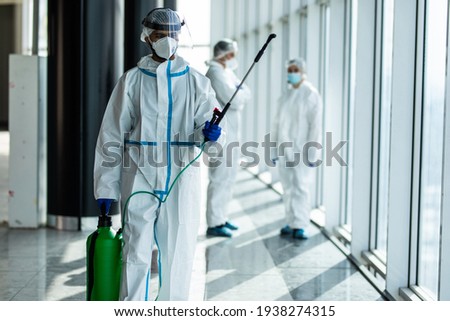 Disinfection, decontaminating due to coronavirus covid19 contagion. Hygiene specialist in protective clothing sprays disinfectant liquidin hospital